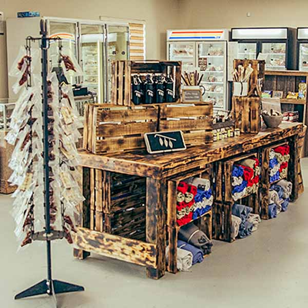 Rustic wooden display at Quapaw Farmers Market featuring local products, apparel, and handcrafted goods.